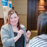 Rebekah Sabo (left) explaining her research